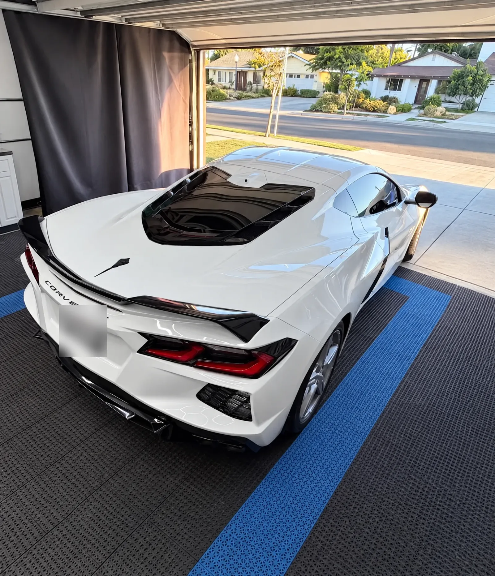 A white Chevrolet Corvette with a tinted back window in the Tint-One workshop in Huntington Beach