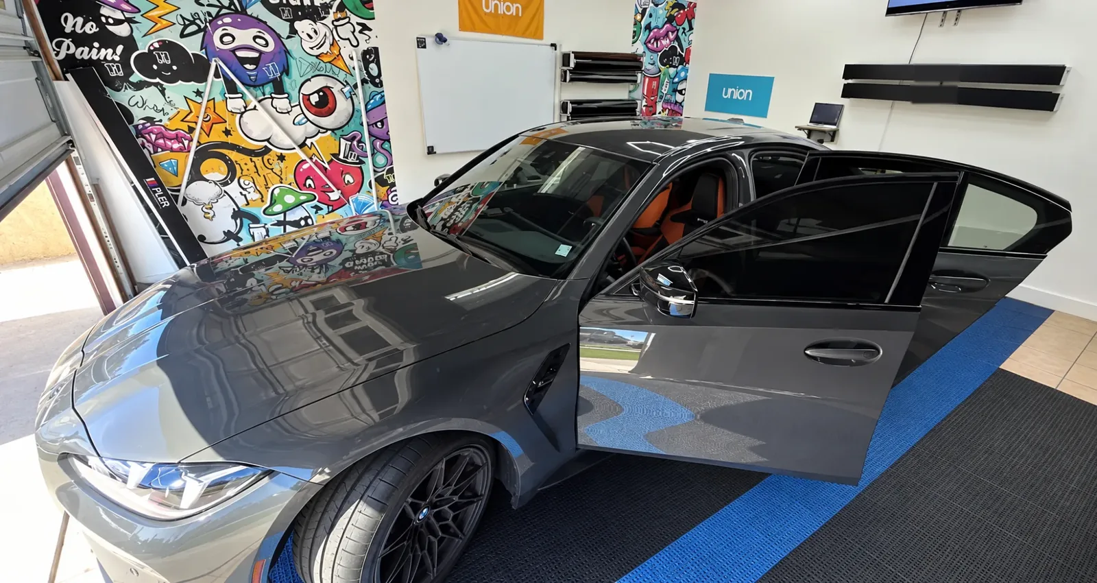 A gray BMW M3 having its windows tinted in the Tint-One workshop in Huntington Beach