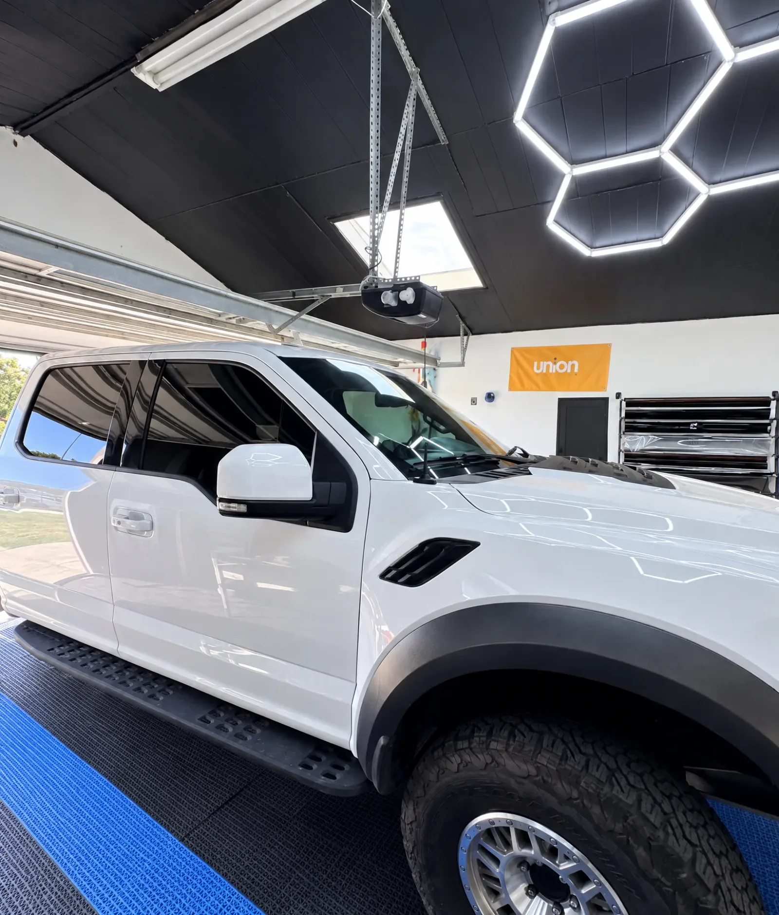 A white Ford Raptor with tinted windows in the Tint-One workshop in Huntington Beach