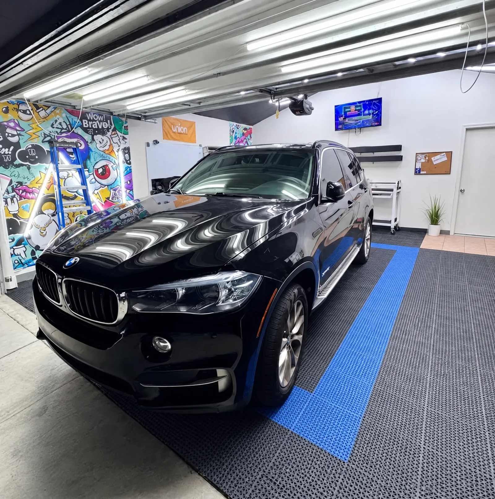 A black BMW X5 with tinted windows in the Tint-One workshop in Huntington Beach