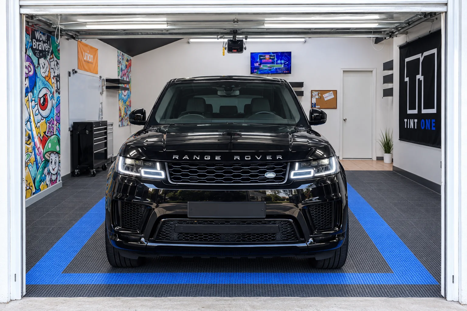 A black Range Rover Sport with tinted windows ready to drive out of the Tint-One workshop